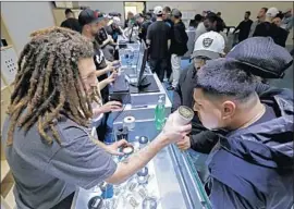  ?? Gary Coronado Los Angeles Times ?? SHANT DAMIRDJIAN assists a customer at the January opening of Cookies Los Angeles, the first recreation­al marijuana dispensary in Maywood.