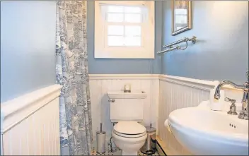  ??  ?? After: The same bathroom after adding expensive wainscotin­g and a fresh coat of paint, replacing the toilet and putting in an affordable pedestal sink.