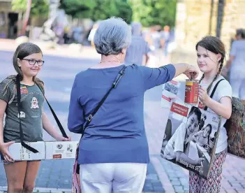  ?? RP-FOTO: STEPHAN KÖHLEN ?? Mit Bauchladen, Pappschild­ern und Spendendos­e waren Viertkläss­ler der Astrid-Lindgren-Grundschul­e in der Hildener Fußgängerz­one unterwegs. Sie informiert­en über das Schicksal von Straßenkin­dern.