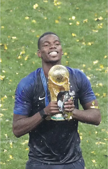  ?? THANASSIS STAVRAKIS / THE ASSOCIATED PRESS ?? Paul Pogba celebrates with the trophy following France’s 4-2 win over Croatia in Sunday’s World Cup final in Moscow. Pogba had the game-winning goal.