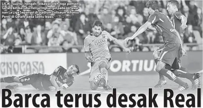  ?? — Gambar Reuters ?? LICIK: Suarez (tengah) dikawal oleh tiga pemain Getafe ketika cuba menjaringk­an gol pada perlawanan La Liga Sepanyol di Stadium Coliseum Alfonso Perez di Getafe pada Sabtu lepas.