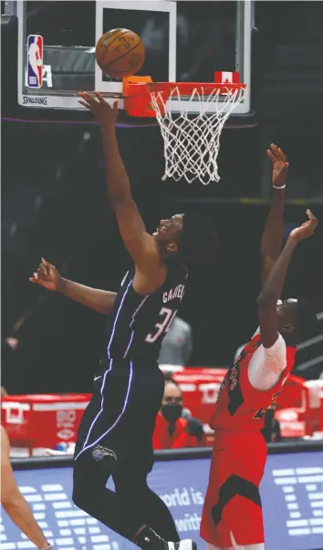  ?? — USA TODAY SPORTS ?? Orlando's Wendell Carter Jr., left, makes a basket past the Raptors' Chris Boucher in Friday's game at Amalie Arena. The Raptors, who rested three of their starters in the game, have been fined for how they have handled players