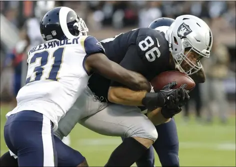  ??  ?? Oakland Raiders tight end Lee Smith (center) catches a touchdown pass against Los Angeles Rams free safety Maurice Alexander (left) during the first half of an NFL preseason football game in Oakland, on Saturday. AP PHOTO/RICH PEDRONCELL­I