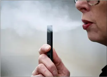  ?? CRAIG MITCHELLDY­ER — THE ASSOCIATED PRESS FILE ?? In this file photo, a woman exhales a puff of vapor from a Juul pen in Vancouver, Wash. A former Juul Labs executive is alleging that the vaping company knowingly shipped 1million tainted nicotine pods to customers. The allegation comes in a lawsuit filed Tuesday, Oct. 29, by a former finance executive who was fired by the vaping giant earlier this year.