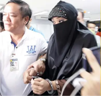  ?? AP FOTO ?? THREAT: Karen Aizha Hamidon (right), allegedly worked to encourage several Indian militants last year to join the Islamic State group in the Middle East. She is escorted to the Department of Justice in Manila.