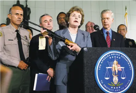  ?? Damian Dovarganes / Associated Press 2003 ?? Sen. Diane Feinstein holds up a Chinese-made AK-47 at a news conference in 2003 as then-Gov. Gray Davis (right) watches.