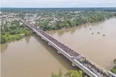  ??  ?? La caravana de migrantes hondureños fue frenada con una barrera fronteriza en el puente internacio­nal Guatemala-México, en Chiapas.