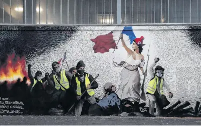  ?? PHOTO: REUTERS ?? Imagery . . . A new mural by artist Pascal Boyart (aka PBOY) to pay homage to the yellow vests movement, inspired by the famous painting Liberty Leading the People by Eugene Delacroix, is pictured on a wall in Paris.