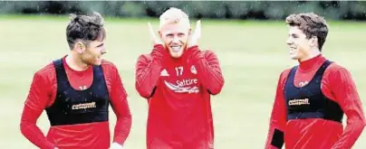  ??  ?? First day back: Greg Tansey, left, with team-mates Jayden Stockley and Ryan Christie during training yesterday and, right, the Dons new boy stretches to it