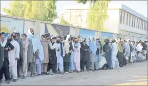  ?? PHOTOS BY THE ASSOCIATED PRESS ?? Men line up to enter a polling station Saturday for in during parliament­ary elections in Kandahar, south of Afghanista­n, that were delayed in the province after an attack by an elite guard.