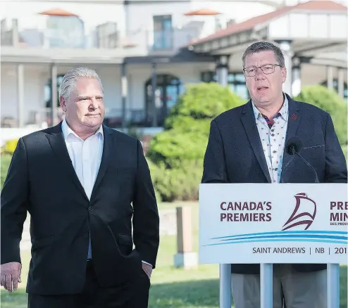  ?? ANDREW VAUGHAN / THE CANADIAN PRESS ?? Ontario Premier Doug Ford, left, and Saskatchew­an Premier Scott Moe in St. Andrews, N.B., on Thursday.