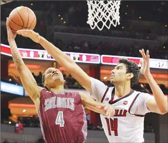  ??  ?? Southern Illinois guard Eric McGill (4) attempts a shot over Louisville forward Anas Mahmoud (14) during the first
half of an NCAA college basketball game on Nov 21, in Louisville, Ky. (AP)