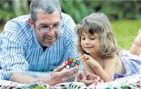  ?? Picture: Jackie Clausen ?? Zoe Grove learns to solve a Rubik's Cube with her father Leon Grove.