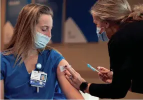  ?? ANDREW NELLES/THE TENNESSEAN ?? Alexa Zarlengo receives a COVID-19 vaccine from fellow nurse Debbie Mahoney at Ascension Saint Thomas Hospital West in Nashville on Dec. 17. Teachers are now the next priority to get shots.