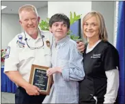  ?? kevin Myrick ?? Marty Robinson, his son Holden and partner Tammy Jarrell pose for a picture after Robinson received Redmond’s Frist Humanitari­an Award on Feb. 13.