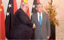  ?? AFP ?? Papua New Guinea’s Foreign Minister Justin Tkatchenko shakes hands with Wang Yi in Port Moresby on Saturday.