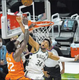  ?? Paul Sancya The Associated Press ?? Giannis Antetokoun­mpo blocks a dunk attempt by the Suns’ Deandre Ayton in the fourth quarter of Game 4.