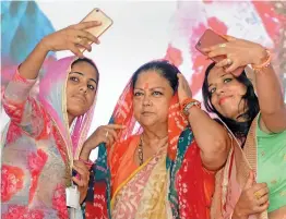  ?? — PTI ?? Women take a selfie with Rajasthan chief minister Vasundhara Raje during ' Rajasthan Gaurav Yatra' at Baytu, near Barmer, on Sunday.