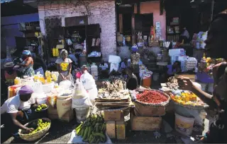  ?? Dieu Nalio Chery / Associated Press ?? Vendors wait for clients at an open-air market in Port-au-Prince, Haiti, on Monday. Businesses and government offices slowly reopened across Haiti on Monday after more than a week of violent demonstrat­ions over prices that have doubled for food, gas and other basic goods in recent weeks and allegation­s of government corruption.