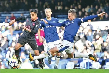  ??  ?? Arsenal’s Chilean striker Alexis Sanchez (L) avoids a challenge from Everton’s English defender Phil Jagielka (R) on his way to scoring their fifth goal during the English Premier League football match between Everton and Arsenal at Goodison Park in...