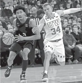  ?? MARK HOFFMAN, MILWAUKEE JOURNAL SENTINEL ?? Wisconsin guard Brad Davison fouls Michigan State guard Jaden Akins during the first half Friday.