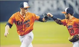  ?? Matt Brown ?? CAL STATE FULLERTON’S Thomas Eshelman, left, bumps fists with infielder Dustin Vaught in February game; the Titans will face Louisville on Saturday.