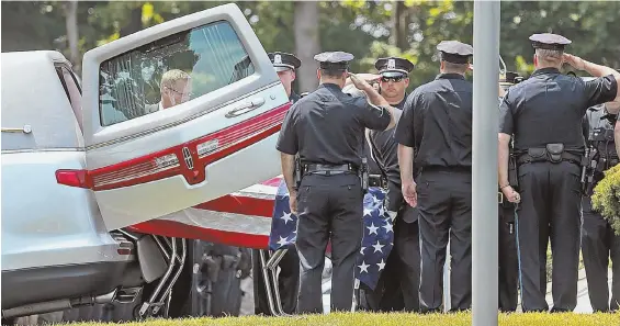  ?? STAFF PHOTO BY MATT STONE ?? HONORING THEIR BROTHER: Police officers salute as the casket of slain Weymouth police Sgt. Michael Chesna is taken out of the hearse in front of McDonald Keohane Funeral Home yesterday.