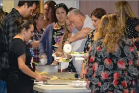  ?? RECORDER PHOTO BY ALEXIS ESPINOZA ?? Guests at the H.O.W. dinner honoring Mandy Childress take their place in line to fill their plates with food catered by Caroline’s Kitchen at the Ed Flory Veterans Memorial Building Wednesday night.