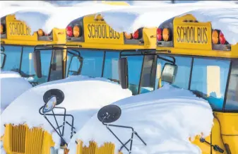  ?? H. Scott Hoffmann / Associated Press ?? School buses sit covered with snow in Greensboro, N.C. Sixty school districts remain closed after the storm dumped more than 2 feet of snow in western parts of the state.