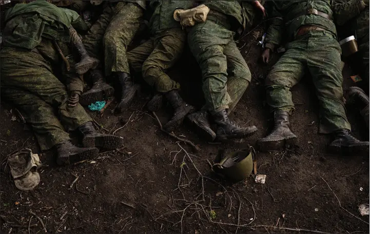  ?? FELIPE DANA / ASSOCIATED PRESS FILE (2022) ?? The bodies of 11 Russian soldiers lie on the ground May 9, 2022, in the village of Vilkhivka near Kharkiv, Ukraine. More than half a million people have been killed or seriously injured in two years of war in Ukraine, according to Western intelligen­ce estimates — a human toll not seen in Europe since World War II.