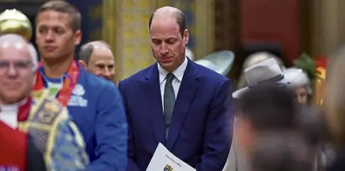  ?? ?? CELEBRATIO­N OF NATIONS: William attends the service, with Queen Camilla, below left, and smelling some flowers.