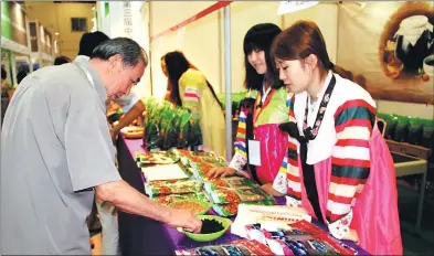  ?? WANG QIAN / CHINA DAILY ?? Sales people clad in Korean costumes promote food products at a Korean goods expo in Jinan, capital of Shandong province.