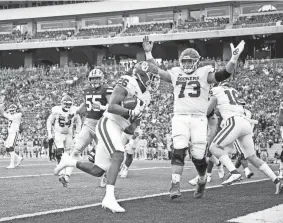  ?? IAN MAULE/TULSA WORLD ?? OU offensive lineman Andrew Raym (73) celebrates as running back Kennedy Brooks scores a touchdown during the Sooners' 37-31 win at Kansas State on Saturday.