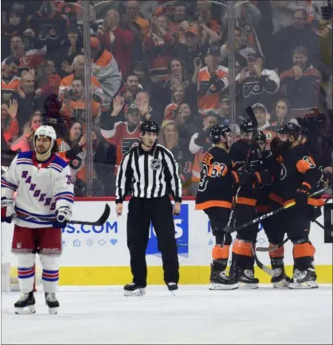  ?? DERIK HAMILTON — THE ASSOCIATED PRESS ?? The Flyers celebrate a goal by Sean Couturier during the third period Friday. Couturier scored twice in a 4-0 Flyers win.