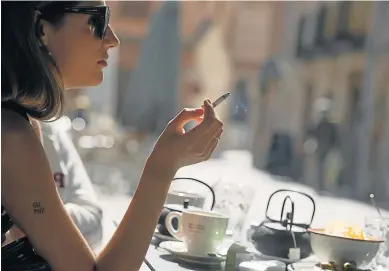  ?? E. SAN BERNARDO ?? Una mujer fuma un cigarrillo en la terraza de un bar.