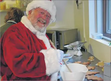  ??  ?? Father Christmas does some baking