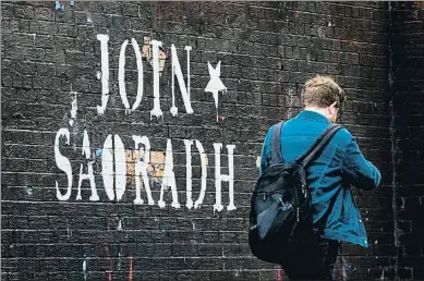  ?? LIAM MCBURNEY - PA IMAGES / GETTY ?? Una pintada en un mur de Belfast convida a afegir-se al Saoradh, el presumpte braç polític del Nou IRA