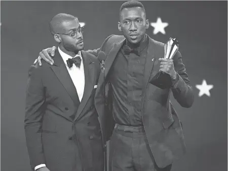  ??  ?? Mahershala Ali, right, brings Kris Bowers, composer for “Green Book,” on stage. CHRIS PIZZELLO/INVISION/AP