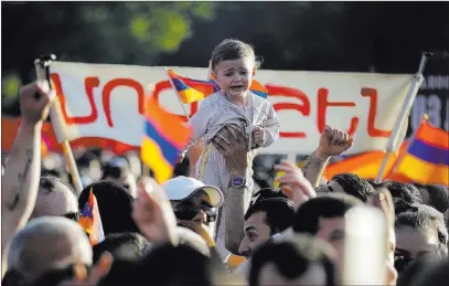  ?? Sergei Grits ?? The Associated Press A young child is held aloft Wednesday by supporters of opposition lawmaker Nikol Pashinian in Republic Square in Yerevan.