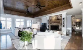  ?? ?? A wood-burning fireplace with a stone surround and a wooden mantel serves as the great room’s focal point.