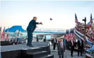  ?? AP PHOTO/ EVAN VUCCI ?? President Donald Trump tosses face masks into the crowd as he arrives Monday for a campaign rally at Orlando Sanford Internatio­nal Airport in Sanford, Fla.