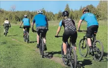  ?? MARISSA LENTZ SPECIAL TO THE EXAMINER ?? Cyclists ride the Harold Town Conservati­on Area trails for the first time in 2018 on Wednesday morning.