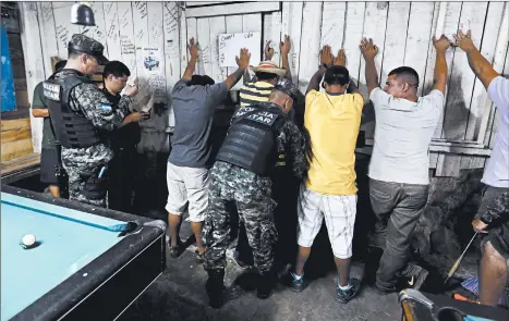  ?? EDUARDO VERDUGO/AP ?? Soldiers enter a billiards hall to frisk the locals as part of a routine patrol in Tegucigalp­a, Honduras. The U.S. government’s interests in Honduras start with battling drug traffickin­g.