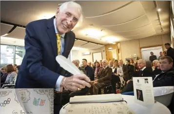  ??  ?? Dr Ronnie Delany signs the distinguis­hed visitors book (left) at the civic reception in his honour last Wednesday morning.