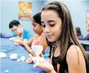  ?? Jerry Baker ?? Isabela Padilla works on her flower made from modeling clay during a class at the Discovery College Summer Camp at Lone Star College—Montgomery.