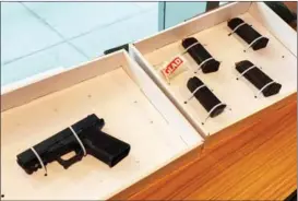 ?? CHINA DAILY ?? A semiautoma­tic Glock pistol and magazines are among a cache of weapons seized by police in Hong Kong on Dec 8.