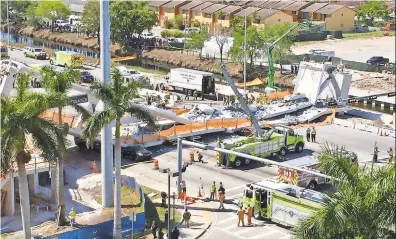  ??  ?? ALAN GOMEZ/USA TODAY Emergency workers respond to a collapsed pedestrian bridge at Florida Internatio­nal University on Thursday in the Miami area. Search-and-rescue teams used dogs and cranes to go through the rubble.