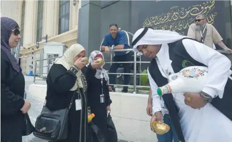  ?? — AFP ?? Saudis offer pilgrims Zamzam water upon their arrival in the holy city of Mecca on Tuesday, ahead of the annual Haj pilgrimage. Millions of pilgrims visit the well each year while performing the Haj or Umrah to drink Zamzam water.