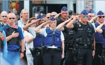  ?? YVES HERMAN / REUTERS ?? Policemen salute during a minute of silence in Liege, Belgium, on Wednesday.