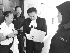  ??  ?? Rubiah (left) talking to her lawyer, Hairul, (second right) outside the courtroom yesterday.